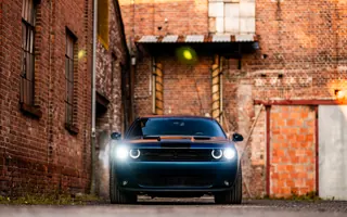 Dodge Challenger widziany z przodu z włączonymi reflektorami