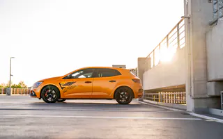Pomarańczowe Renault Megane R.S. Ultime z profilu o zachodzie słońca