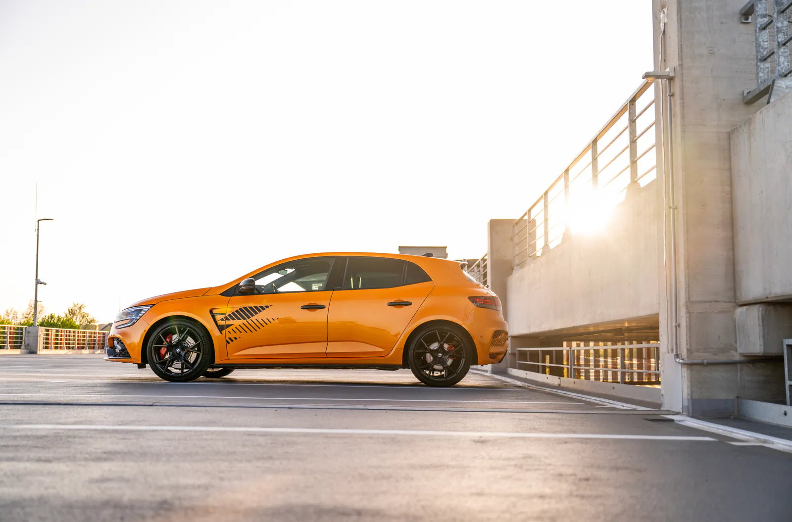 Pomarańczowe Renault Megane R.S. Trophy Ultime z profilu o zachodzie słońca