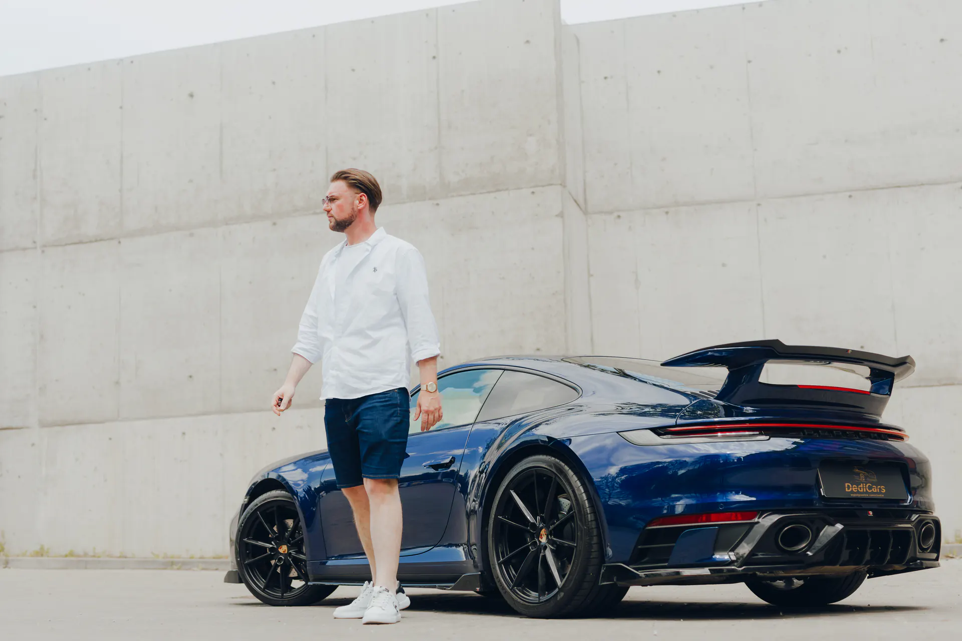 Dawid Pierzchalski przy niebieskim Porsche 911 DediCars