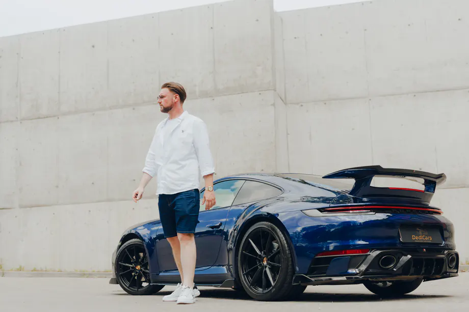 Dawid Pierzchalski przy niebieskim Porsche 911 DediCars